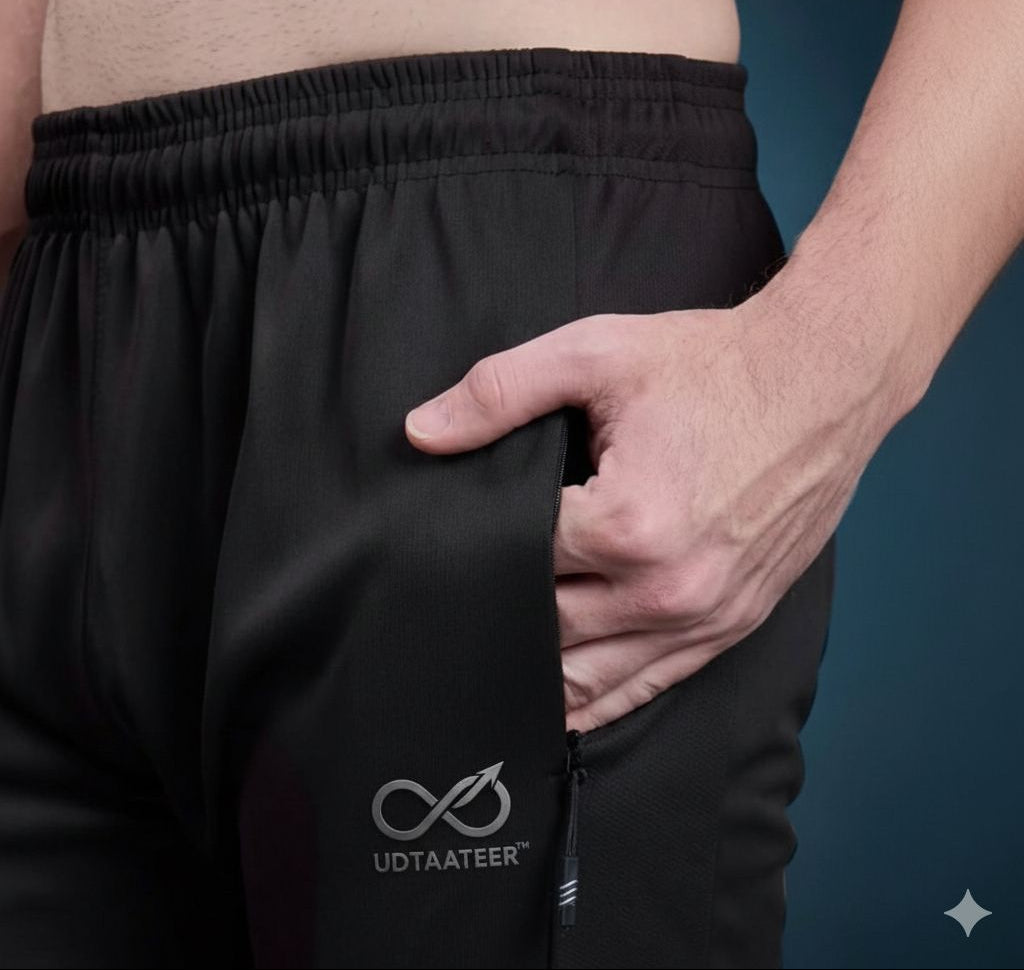 Person wearing black pants with a visible brand logo on a dark background